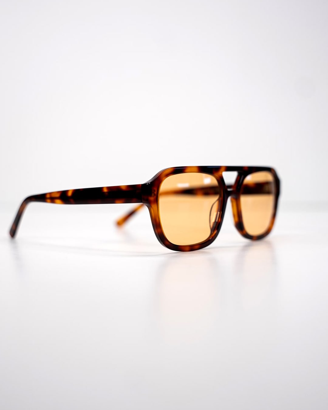 side view of rectangular aviator sunglasses with tortoiseshell acetate frames and amber-tinted lenses