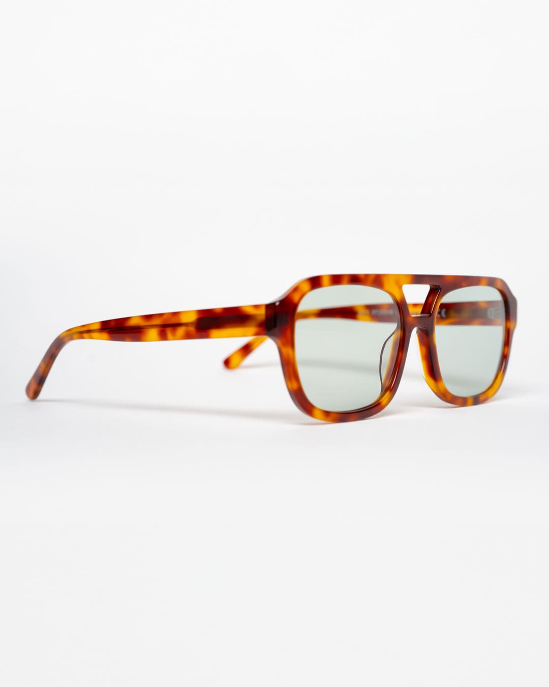 side view of rectangular aviator sunglasses with tortoiseshell acetate frames and green-tinted lenses