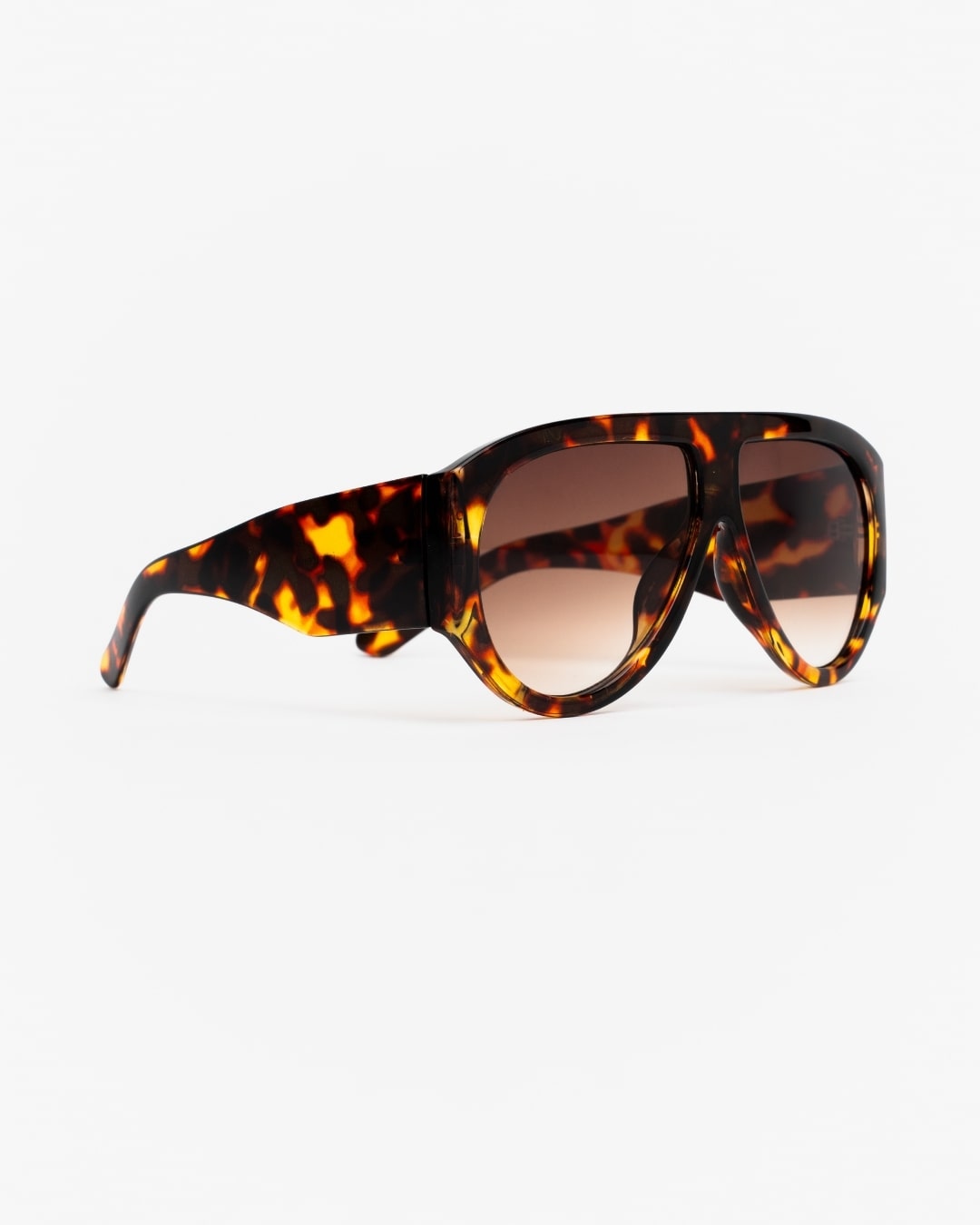 side view of oversized shield sunglasses with tortoiseshell frames and brown gradient lenses