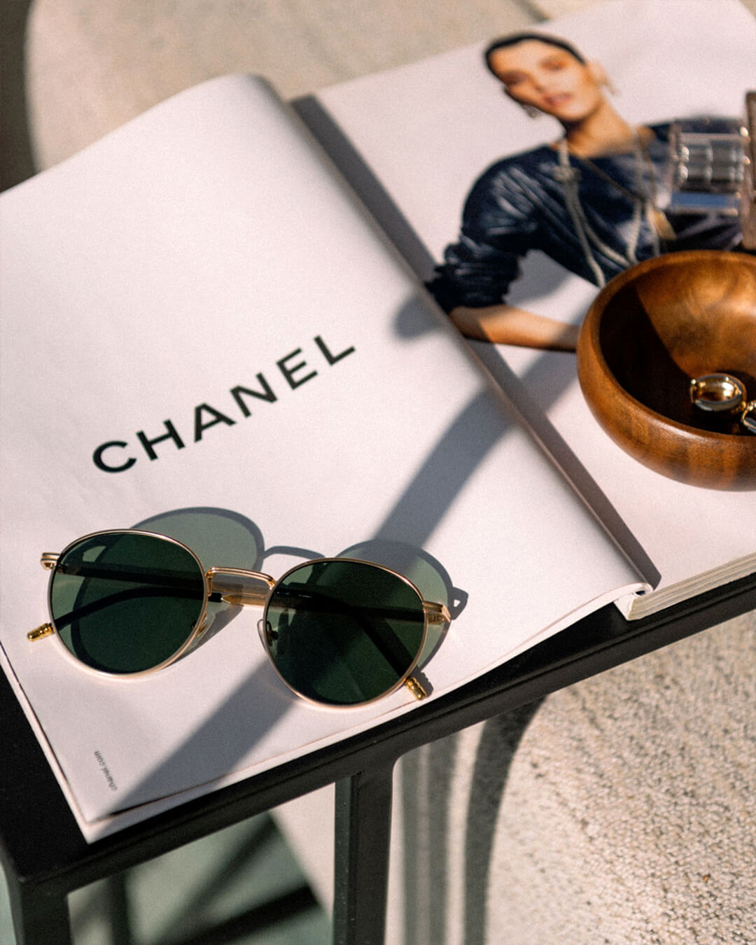 flat lay of round sunglasses with a gold metal frame and polarised forest green lenses