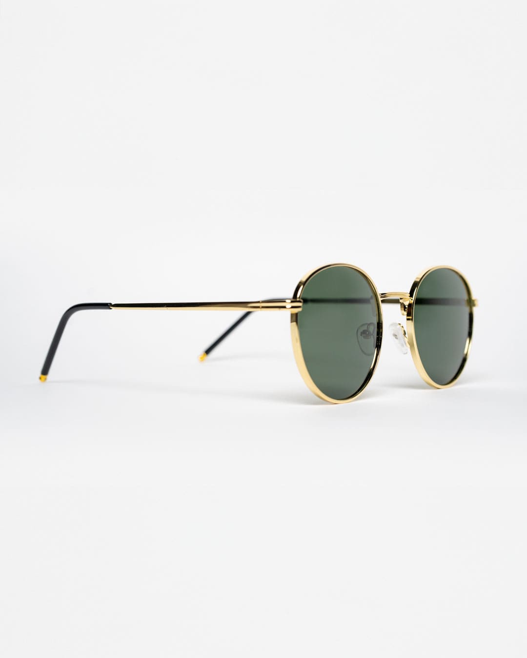 side view of round sunglasses with a gold metal frame and polarised forest green lenses
