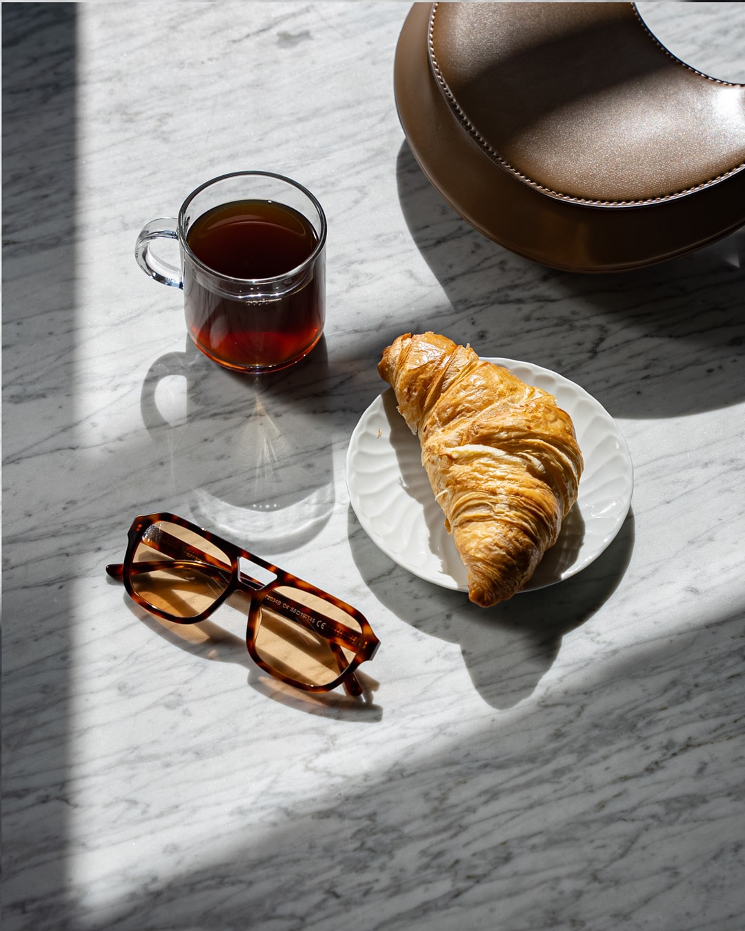 flat lay of rectangular aviator sunglasses with tortoiseshell acetate temples and amber-tinted lenses