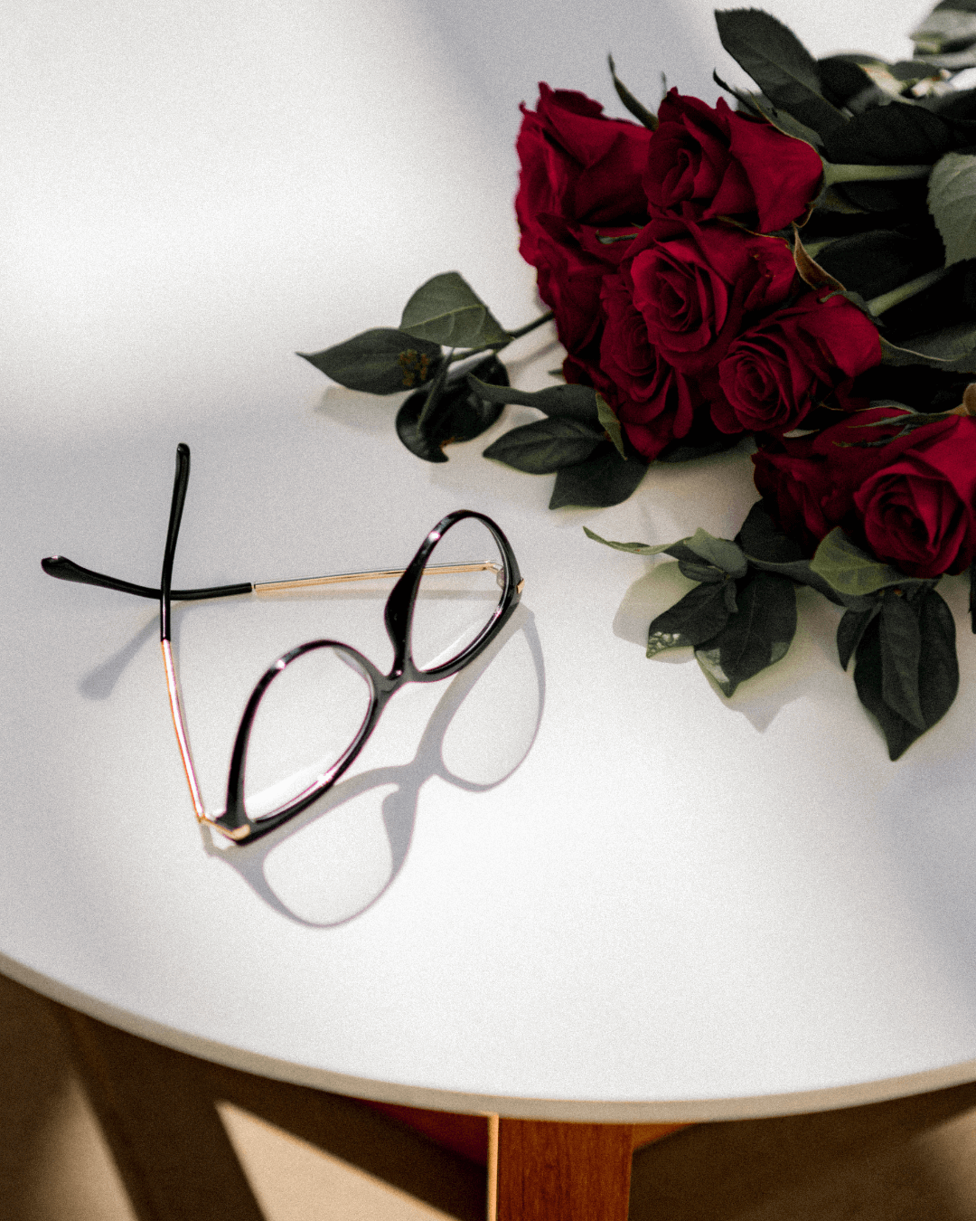 flat lay of cat-eye blue light blocking glasses with a black frame and gold temples