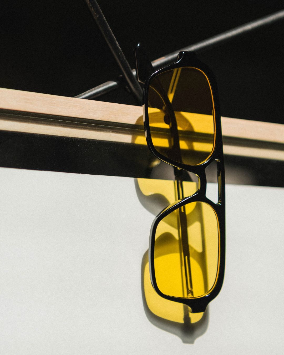 flat lay of aviator sunglasses with yellow lenses and black frames
